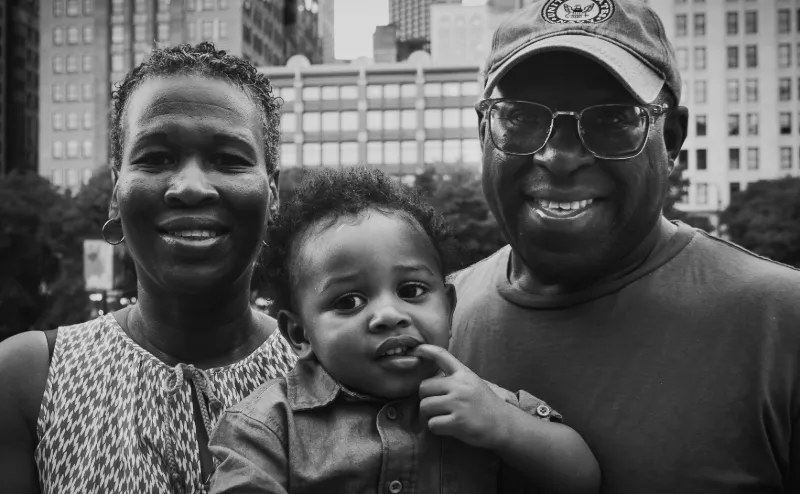 Black-and-white city portrait of grandparents with their toddler